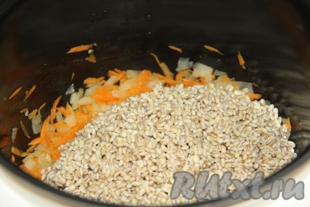 Слить воду с перловки и положить крупу в чашу мультиварки к обжаренным овощам.
