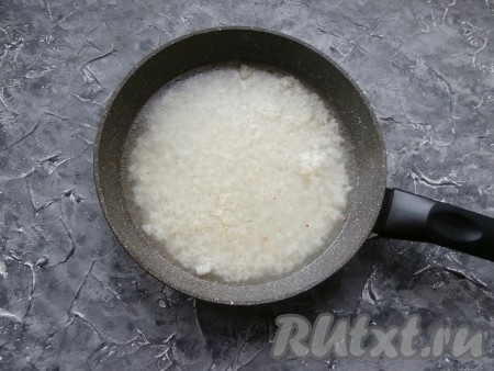 На сковороду с рисом влить 200 мл горячего овощного бульона (или воды), перемешать.
