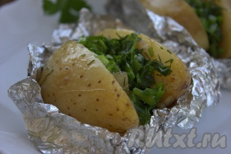 Готовый картофель достать из духовки, развернуть фольгу и выложить зелень с чесноком и маслом к салу между двумя половинок картошки.
