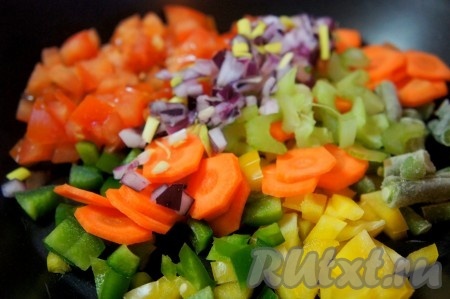 Лук и помидор мелко нарезать, добавить на сковороду к овощам и обжарить, помешивая, в течение 5-7 минут.
