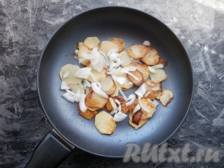 Обжарить картофель на среднем огне до готовности и румяности (в течение 10-12 минут), периодически его перемешивая. Половину луковицы очистить, нарезать тонкими перьями и выложить к жареной картошке, перемешать и обжаривать ещё несколько минут.