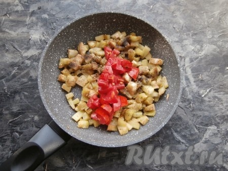 Обжарить баклажан, помешивая, на среднем огне минут 5-6, добавить соль, перец, майоран и специи. Также добавить нарезанный небольшими кусочками свежий помидор.