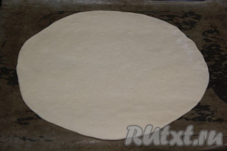 Тесто разделить на две части и раскатать каждую часть теста на присыпанной мукой поверхности в круг диаметром 28 см (мы будем делать 2 пиццы "Цезарь"). Переложить тесто на застеленный бумагой противень и дать отдохнуть 15 минут.