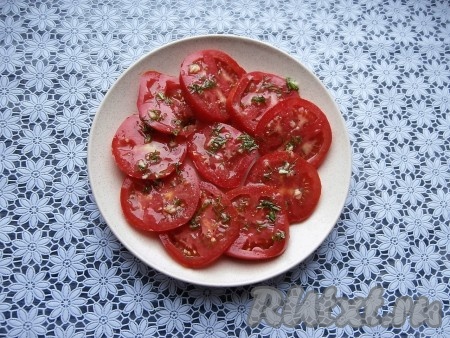 Полить помидоры частью подготовленной заправки, поперчить их.