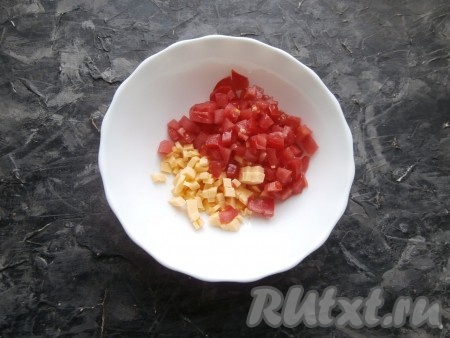 70 грамм сыра и свежие помидоры нарезать маленькими кубиками, выложить в достаточно глубокую тарелку.