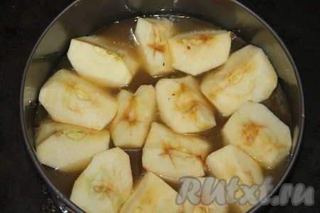 Разъемную форму смазать сливочным маслом. Вылить на дно нашу карамель. Очищенные и разрезанные на четыре части яблоки уложить шляпкой в карамель. Яблоки выкладывать плотно друг к другу.
