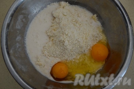 Затем вбить в миску с крошкой 2 сырых куриных яйца и влить молоко.