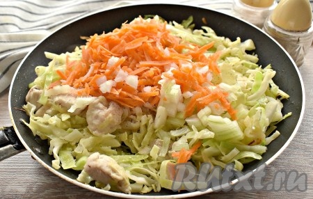 По прошествии 5-7 минут капуста заметно осядет, значит пришло время добавить луковицу, нарезанную достаточно мелко, и натёртую морковку. Содержимое сковороды солим и перчим по вкусу, перемешиваем и накрываем крышкой.