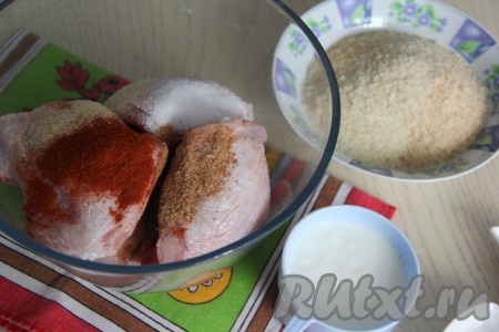 Выложить бёдрышки в миску, добавить к ним специи и соль. 