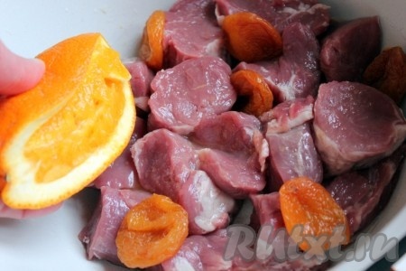 Свинину нарезать на кусочки, добавить курагу и залить соком из апельсина.