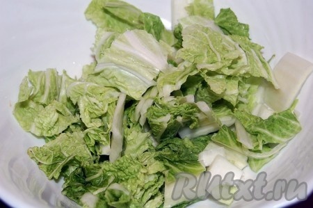 Взять салатник и на дно его уложить слой крупно нарезанной китайской капусты.