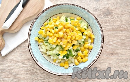 Зёрна консервированной кукурузы вначале откидываем на сито, чтобы слить жидкость, а затем выкладываем в салат.