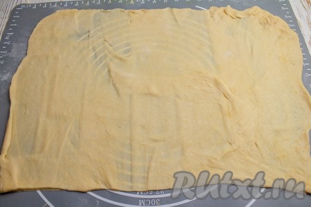 "Отдохнувшее" тесто на слегка припылённой мукой поверхности раскатайте в тонкий пласт толщиной 2-3 мм.