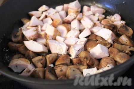 Добавить куриное мясо на сковороду с шампиньонами и немного обжарить их вместе, т.е. чтобы мясо не было холодным.