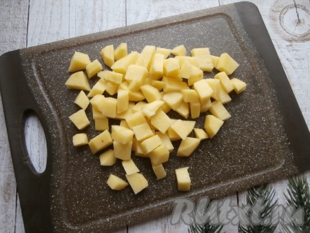Нарезать на кубики очищенный картофель.