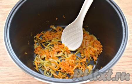 В чашу мультиварки вливаем растительное масло, сразу же выкладываем морковку с луком. Выставляем режим "Жарка". Обжариваем овощи 10 минут, периодически перемешивая. Мультиварку крышкой не накрываем.