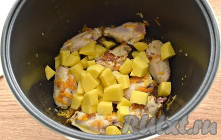 К куриному мясу, обжаренному с овощами, выкладываем нарезанный картофель.