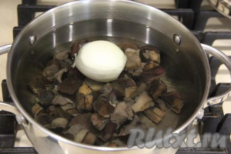 В кастрюлю выложить грибы и очищенную луковицу, влить 1,5 литра холодной воды, поставить на сильный огонь.