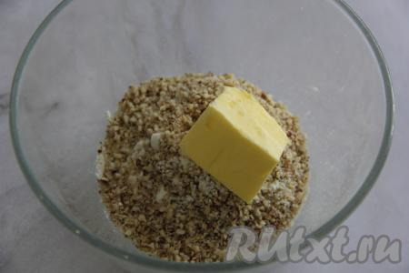 В получившуюся смесь добавить сливочное масло (при желании,  можно предварительно нарезать масло на кусочки), перетереть массу в крошку. 