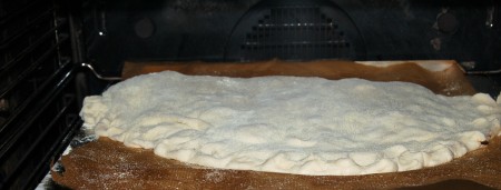 Укладываем нашу пиццу "Кальцоне" на бумагу для выпечки и отправляем в заранее разогретую до 200 градусов духовку на 20-30 минут.
