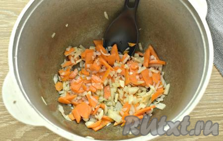 В казан (или глубокую сковороду) наливаем растительное масло, прогреваем его, затем выкладываем нарезанные морковку с луком. На среднем огне обжариваем морковку с луком 4-5 минуты, периодически перемешивая.