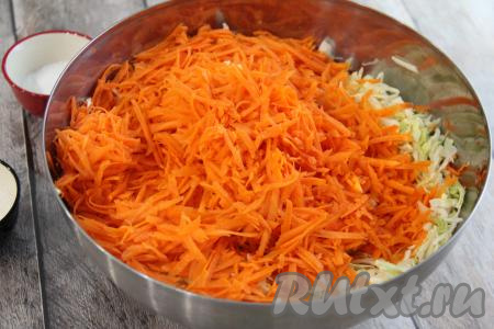 В миску с капустой добавить морковку, натёртую на крупной тёрке, и перемешать.