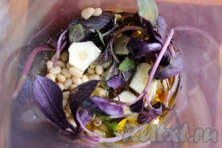 В стакан погружного блендера поместить листья салата, кедровые орешки, чеснок, базилик и залить оливковым маслом.