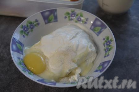 Пока баранки размокают, приготовим начинку. Для этого прежде всего нужно яйцо аккуратно разделить на белок и желток. Белок поместить в холодильник. В достаточно глубокой миске соединить творог, желток, сгущёнку (или 2 столовых ложки сахара), ванильный сахар и сметану.