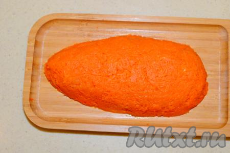 Верх и бока салата будем покрывать варёной морковью, для этого нужно отварить в кожуре до готовности достаточно крупную морковку (на варку с момента закипания воды, в зависимости от размера и сорта, уходит 25-35 минут), остудить, очистить и натереть на мелкой тёрке. Равномерно покрыть варёной морковью бока и верх салата.
