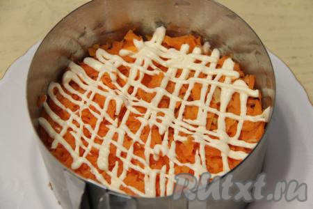 Поверх слоя картофеля равномерно выложить натёртую на крупной тёрке морковку, сделать сеточку из майонеза.