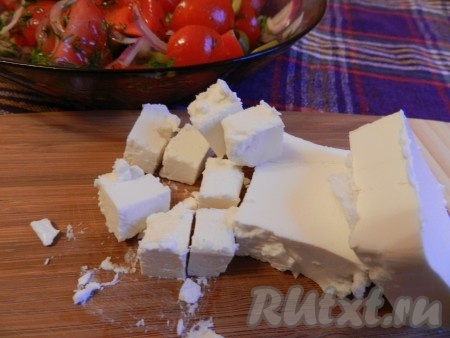 Сыр Фета нарезать кубиками и добавить в салат с помидорами черри и оливками, не перемешивая.
