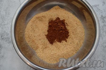 К получившейся смеси из измельчённых сухарей и сахара всыпать какао, перемешать столовой ложкой сухую смесь до однородности.