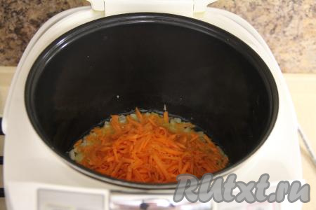 Морковь натереть на крупной тёрке и добавить в чашу мультиварки. Обжаривать овощи минут 5, помешивая.