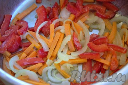 В кастрюлю с толстым дном (или в казан) влить 2-3 столовых ложки растительного масла, выложить нарезанные лук и морковь. Иногда перемешивая, обжарить овощи до мягкости на среднем огне (на это потребуется 7-8 минут). К обжаренным овощам добавить очищенный от семян и плодоножки, нарезанный на достаточно тонкие полоски болгарский перец, хорошо перемешать. 