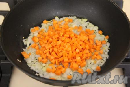 Морковь нарезать на мелкие кубики и добавить к обжаренному луку, перемешать овощи.