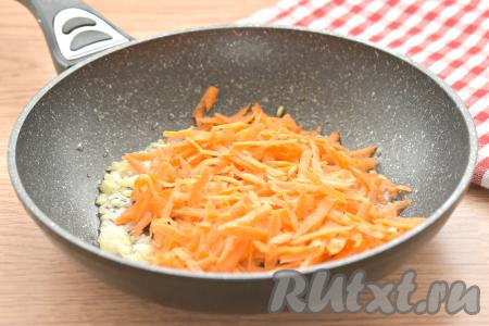 Морковку натираем на крупной тёрке. К мягкому луку выкладываем морковь, перемешиваем, обжариваем овощи, иногда помешивая, минут 5.