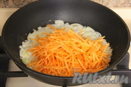 К обжаренному луку добавить натёртую на крупной тёрке морковку, перемешать овощи и обжаривать их минуты 3-4, иногда перемешивая.