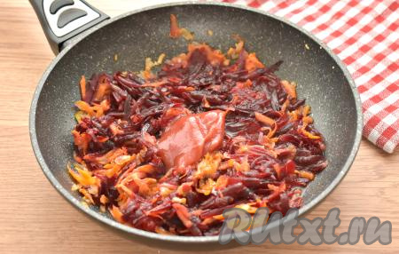 Добавляем томатную пасту, вливаем 2-3 столовых ложки куриного бульона из кастрюли, перемешиваем и тушим овощи на небольшом огне 5 минут, иногда помешивая.