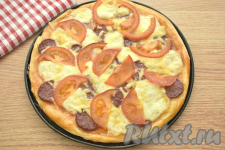 Выпекаем пиццу с моцареллой, колбасой и помидорами в разогретой духовке при температуре 190 градусов 20-25 минут.
