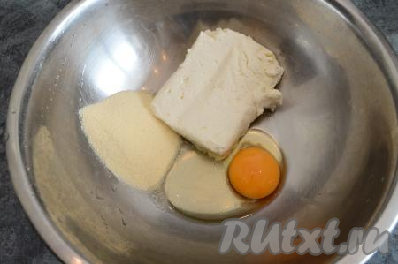 В глубокую миску выложить творог, добавить манку и сырое яйцо.