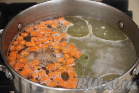 Выложить в кипящий бульон картошку, морковь, куриное мясо и лавровый лист, довести до кипения.