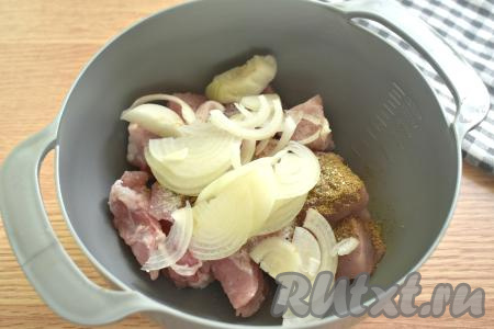Очищаем одну луковицу, затем нарезаем её на тонкие полукольца, добавляем в миску со свининой.