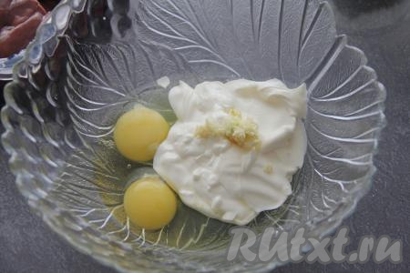Для приготовления кляра соединить в глубокой миске сметану, яйца и пропущенный через пресс чеснок, всыпать соль по вкусу, перемешать до однородности.