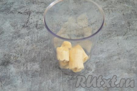 В чашу погружного блендера выложить очищенный банан, поломанный на кусочки.