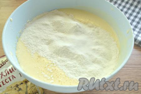 В получившуюся масляно-яичную смесь добавляем разрыхлитель, частями просеиваем муку, каждый раз полностью вмешивая её в тесто для пирога столовой ложкой.