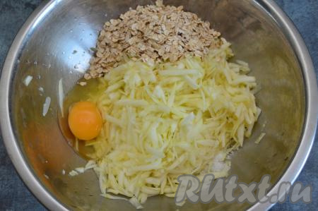 В миску к кабачку, отжатому от сока, всыпать овсяные хлопья, вбить сырое яйцо и добавить соль по вкусу (я добавила 3 щепотки соли).
