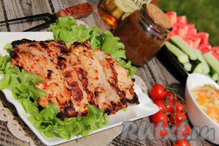 Филе куриных бёдер, приготовленное на мангале, можно подать с нарезанными свежими овощами, зеленью и любимым соусом.