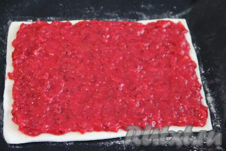 На раскатанный пласт теста, отступив от краёв 1,5-2 сантиметра, выложить ягодную начинку, равномерно распределить.