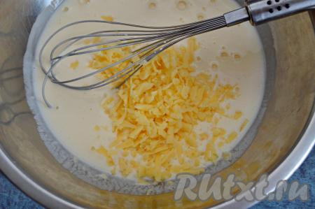 Затем в миску со смесью кефира и яиц добавить сыр, натёртый на крупной тёрке, перемешать.