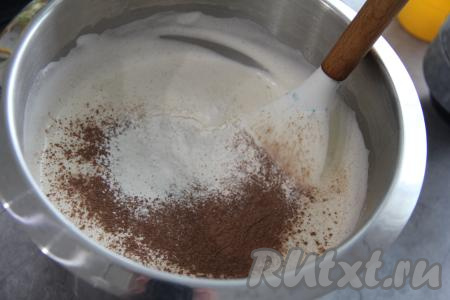 В получившуюся массу влить растительное масло, перемешать лопаткой. Затем всыпать соль, разрыхлитель, какао, часть муки, перемешать лопаткой. Постепенно добавить оставшуюся муку, тщательно вмешивая её лопаткой в тесто. 